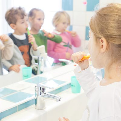 Kinder putzen die Zähne vorm Spiegel