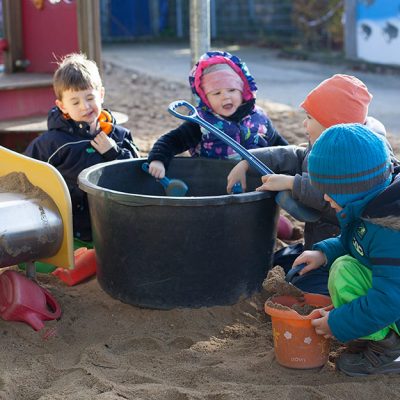 Vier Kinder spielen im Sandkasten